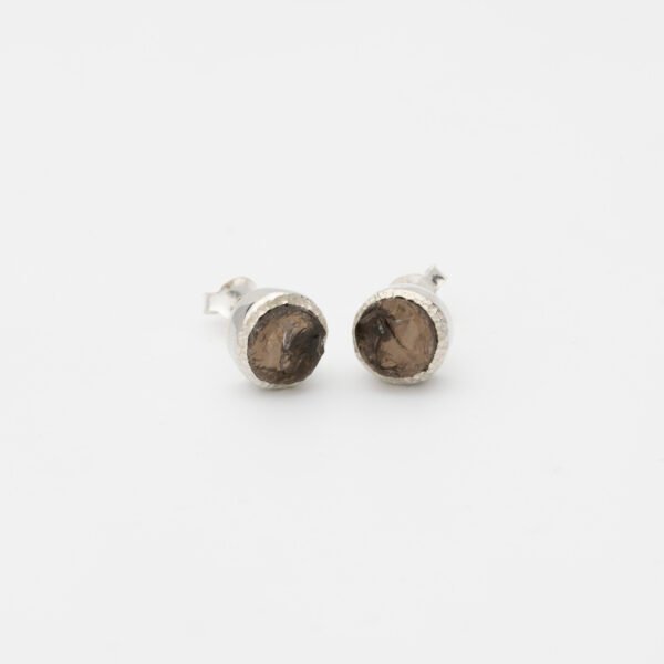 Handcrafted raw smoky topaz stud earrings with grey-brown gemstones set in textured sterling silver. Rustic and organic design with unique stone variations, finished with butterfly backs for secure wear. Perfect for minimalist or boho-inspired styles.